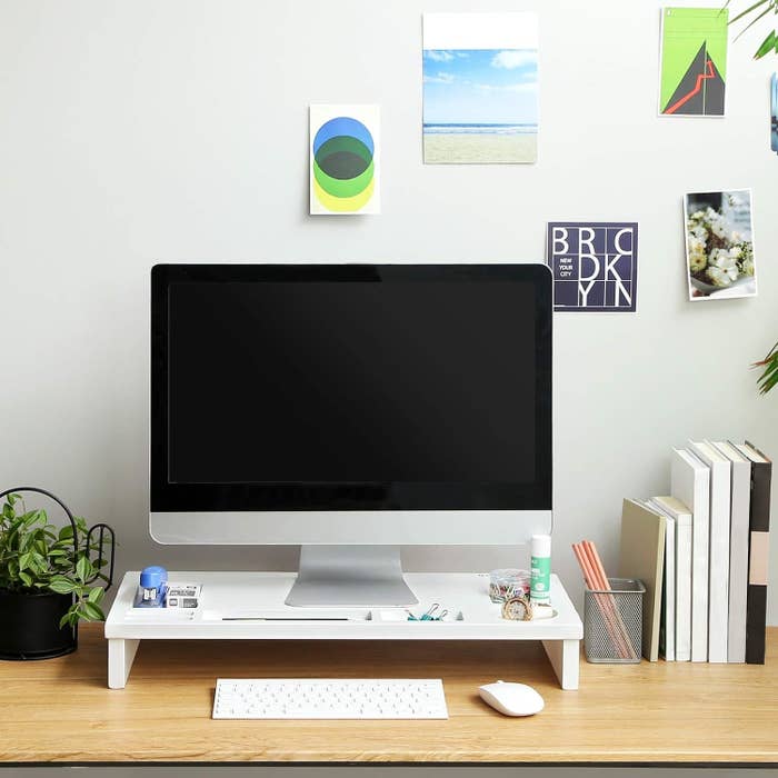 Desk with computer monitor, keyboard, mouse, and decorative items, showcasing a minimalist workstation setup