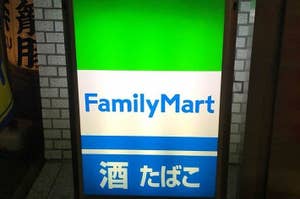 ファミリーマートの看板、上は緑、下は青の背景に店名が表示。