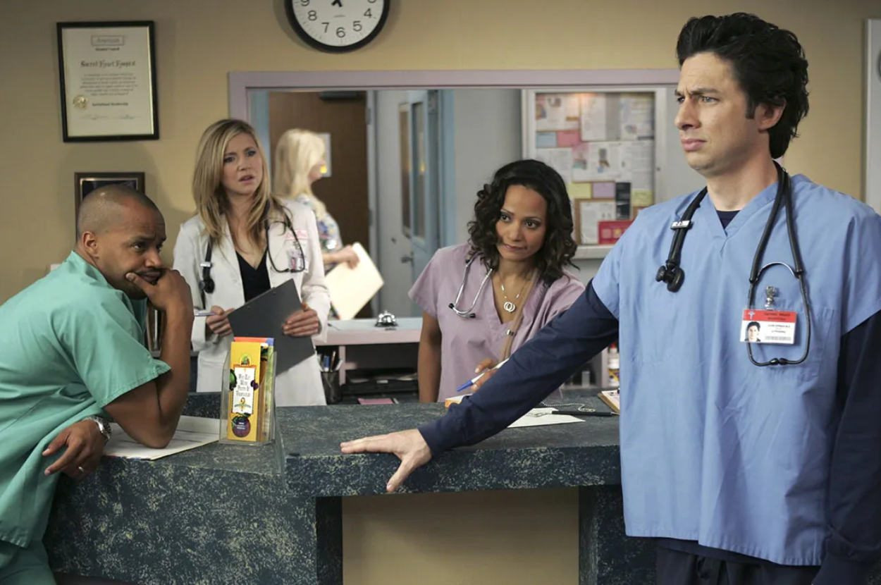 Turk and Carla speaking with J.D. and Elliot in the background at Sacred Heart Hospital from the TV show &quot;Scrubs.&quot;