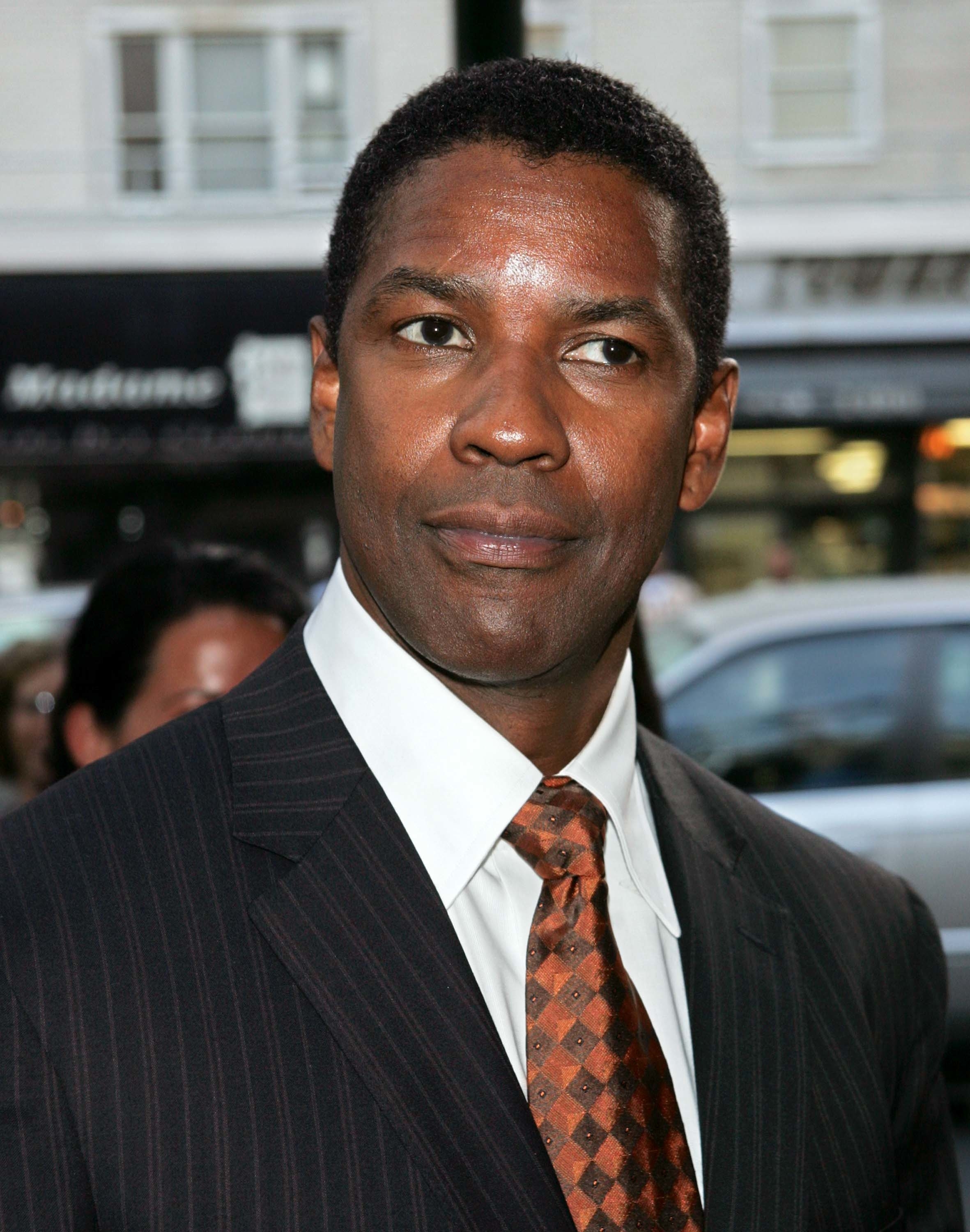 Denzel Washington in a pinstripe suit and patterned tie at an event