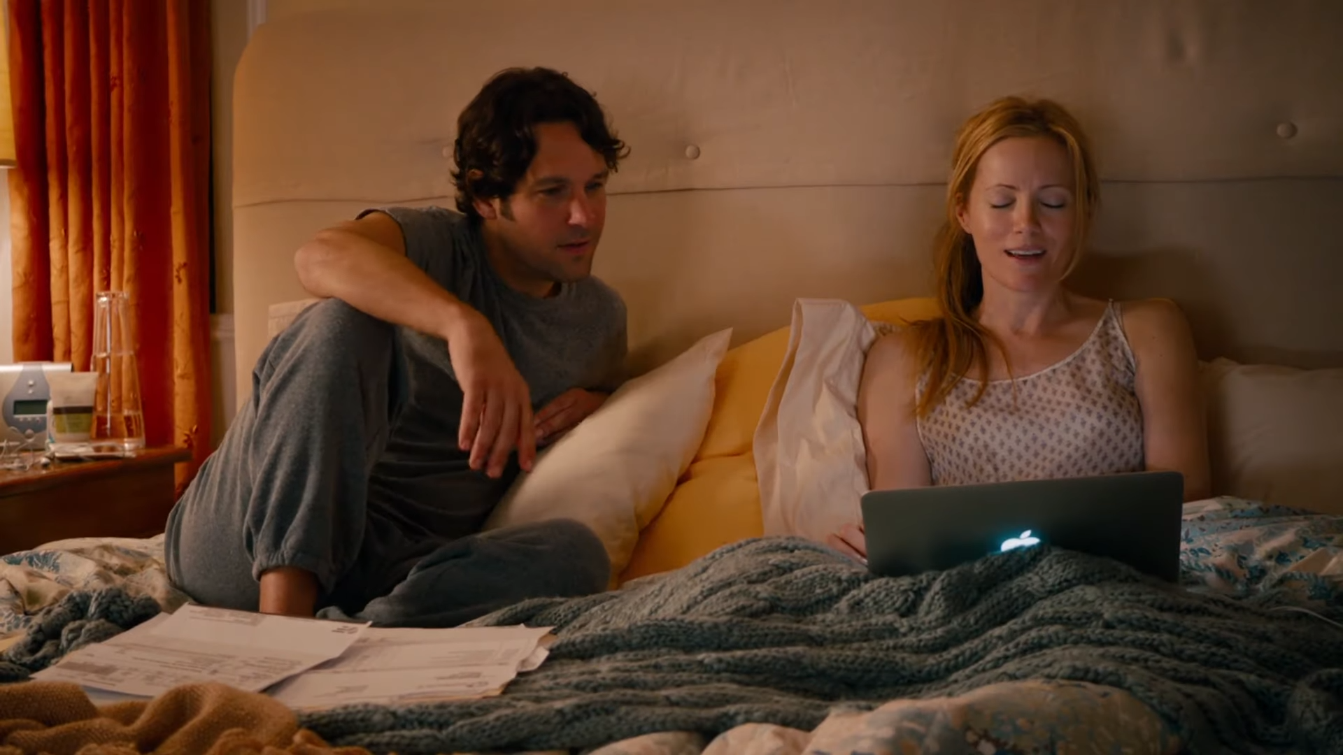 A couple sits in bed with a laptop and papers, looking concerned, in a scene from &quot;This Is 40&quot;
