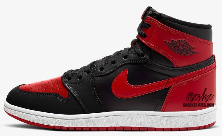 A single Air Jordan 1 sneaker with black overlays, red toe box, and side swoosh, white midsole