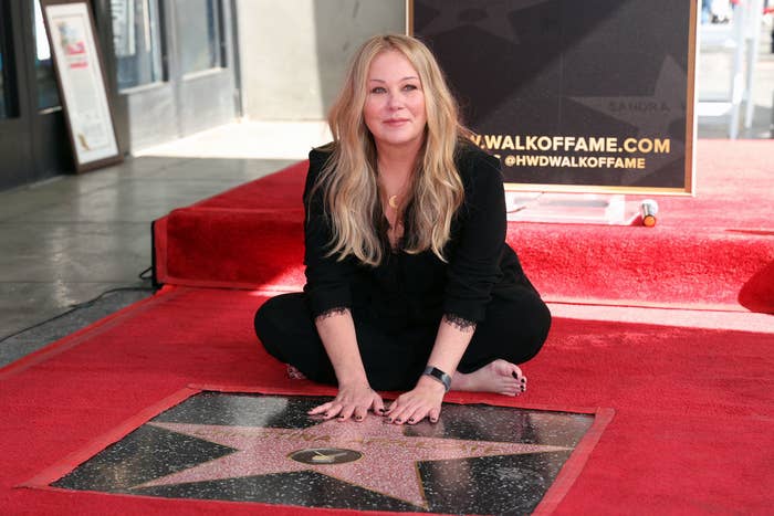 Christina Applegate sitting next to her star on the Hollywood Walk of Fame