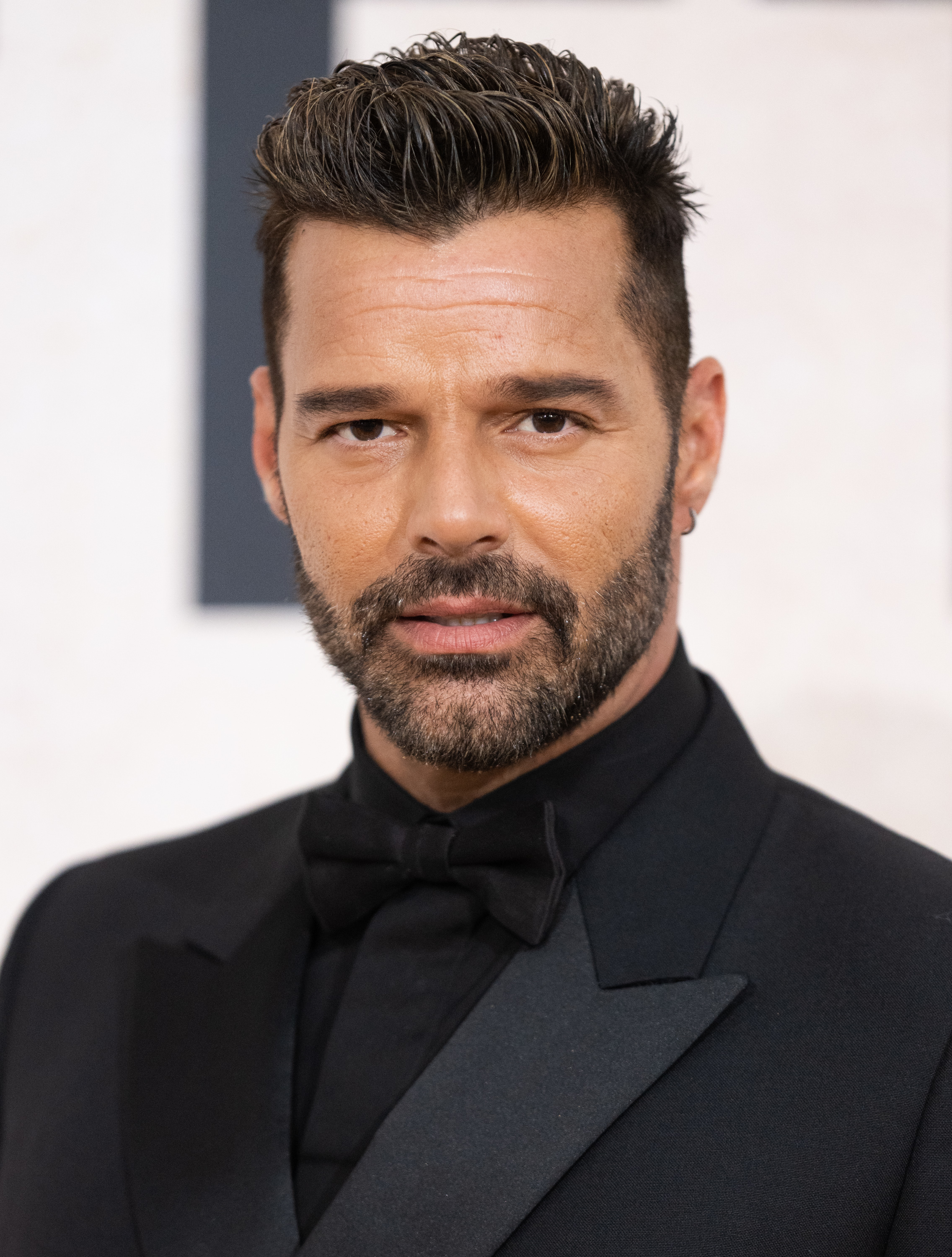 Ricky Martin in a black tuxedo with a bow tie at an event