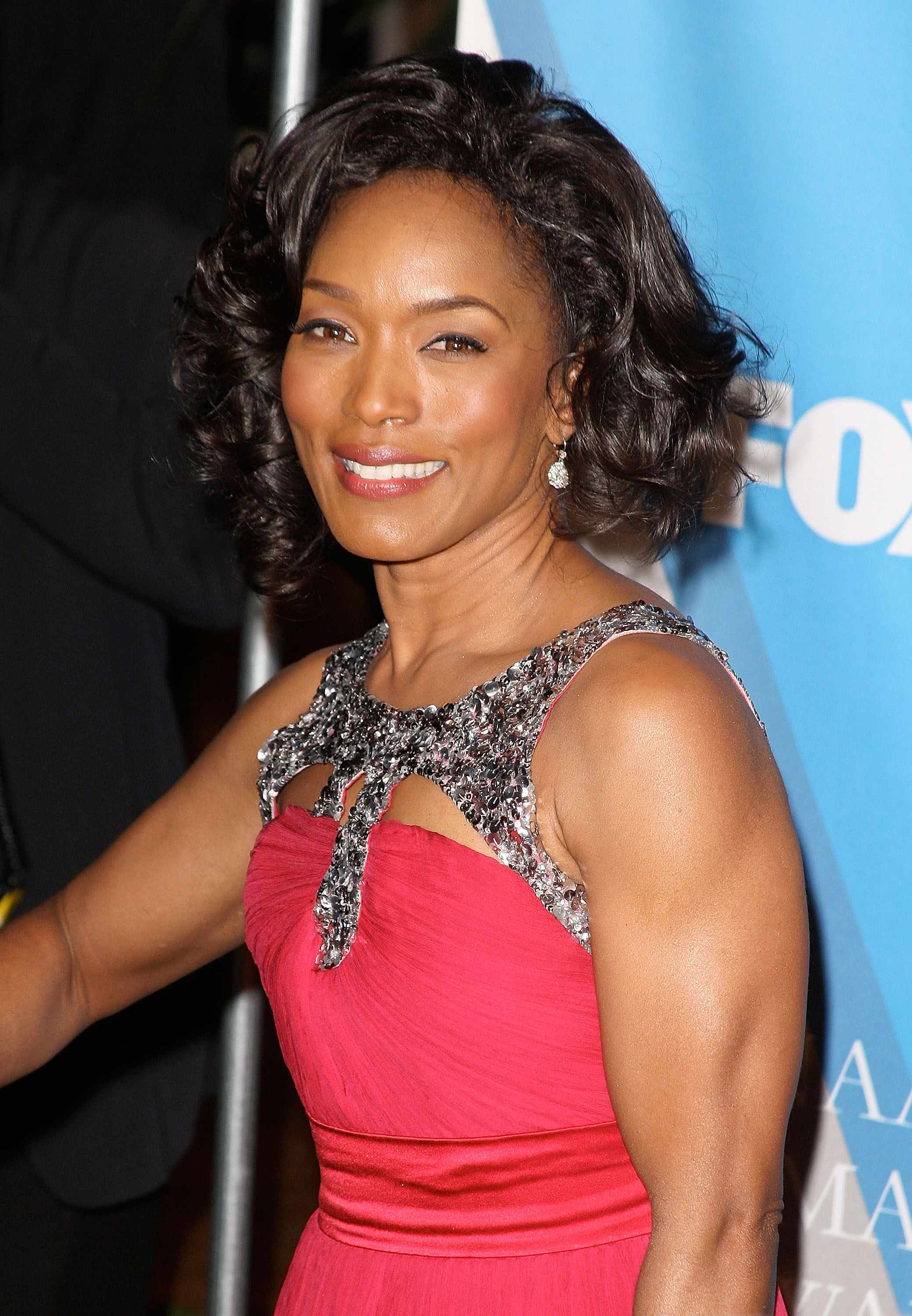 Angela Bassett in a sleeveless red gown with sparkling embellishments at a formal event