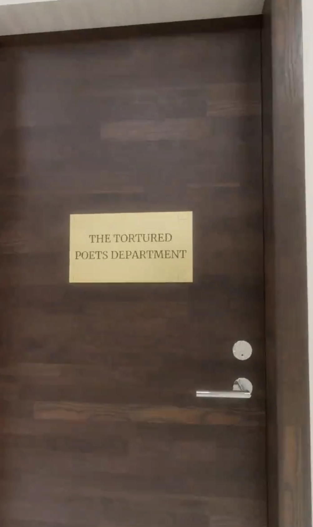 Sign on a wood door reads &quot;THE TORTURED POETS DEPARTMENT.&quot;