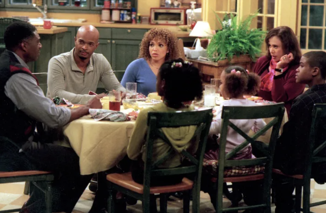 Family gathered around a dinner table in a scene from a television show