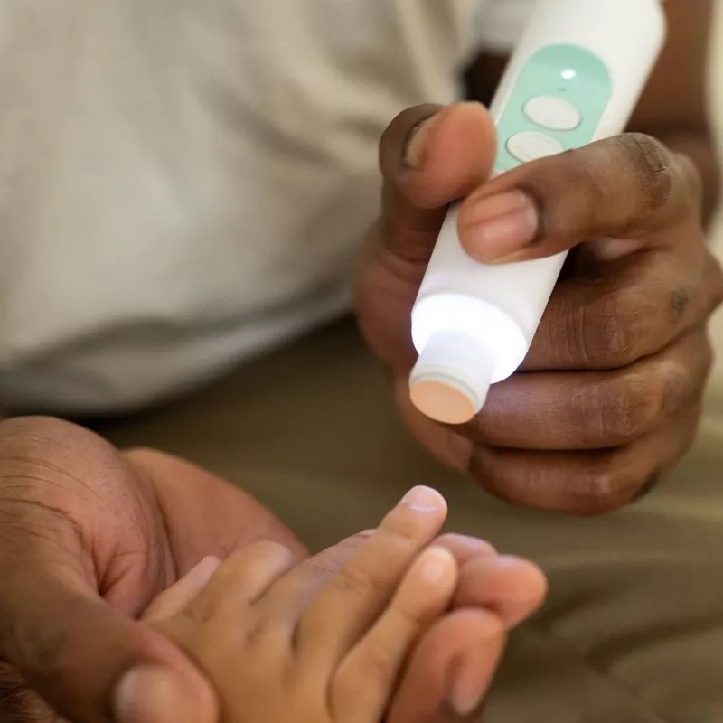 person using the nail trimmer set on baby hands