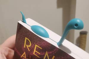 plastic bookmark with a blue nessie shape that's "swimming" in the pages 