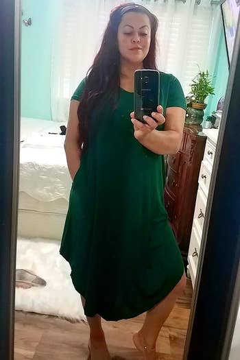 Reviewer's photograph of them wearing the formal successful the colour green, taking a selfie successful the reflector with a phone