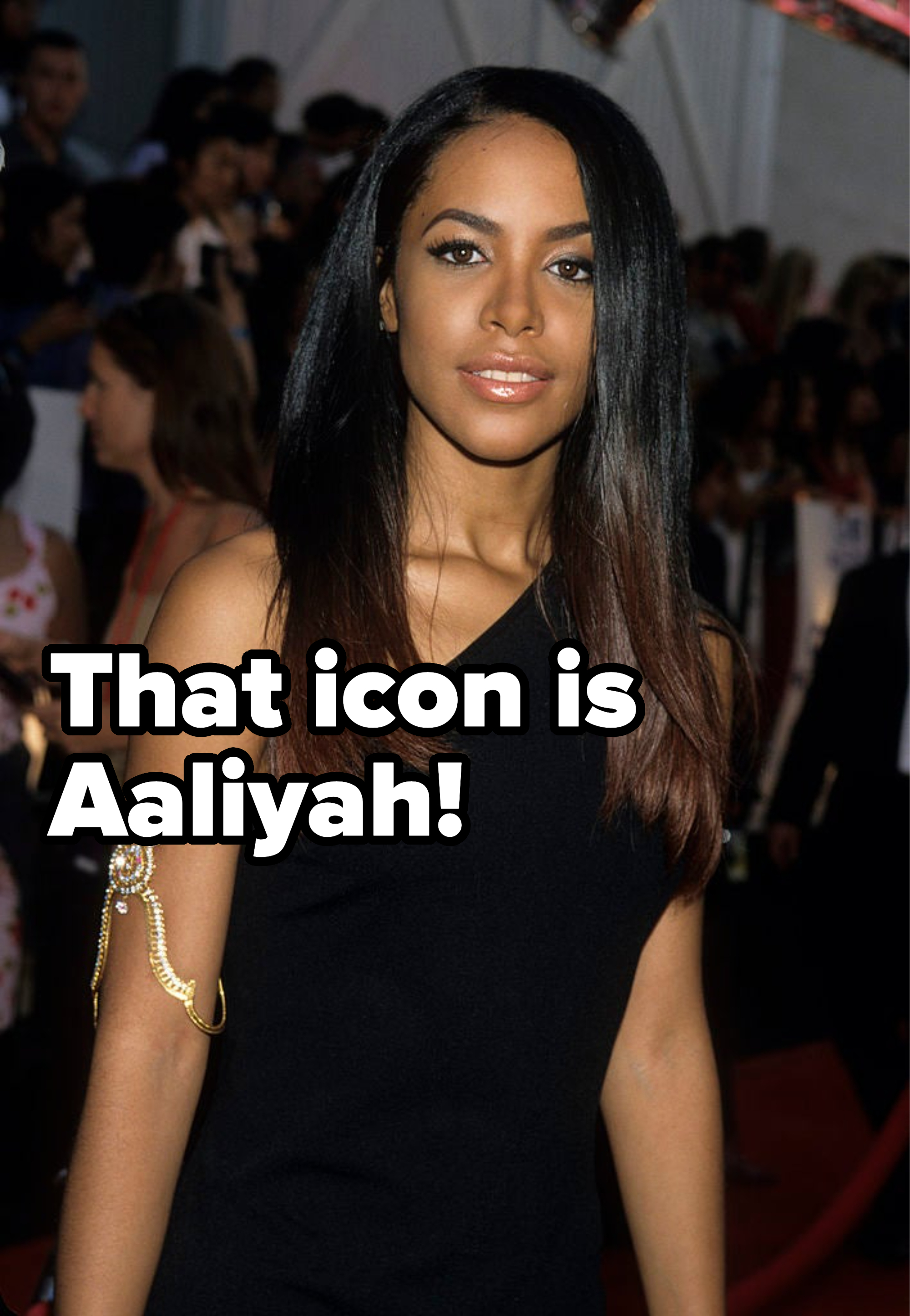 Woman in sleeveless dress posing on the red carpet, with a unique hand accessory