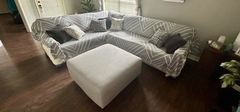 A patterned sofa with throw pillows and a matching ottoman in a living room setting