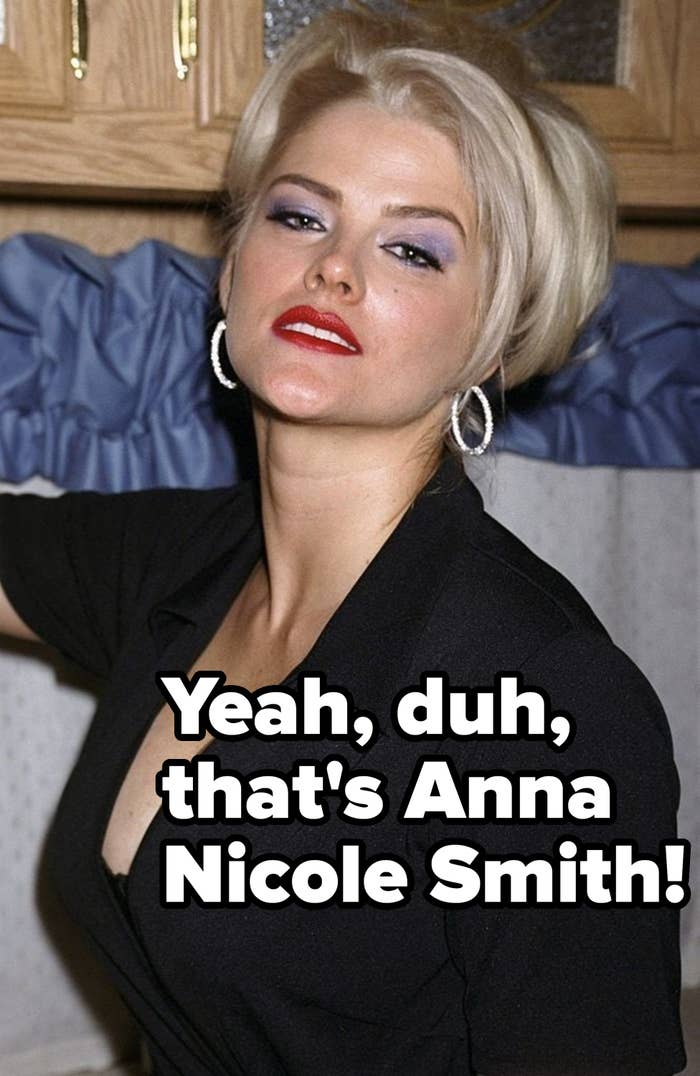 Close-up of [Name], posing at an event, wearing subtle makeup and long wavy hair styled down