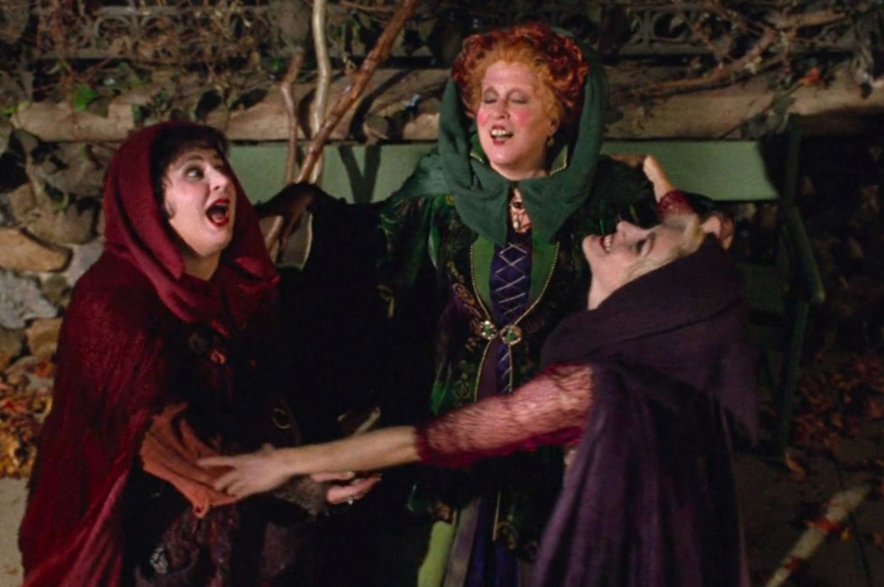 Three characters from Hocus Pocus in a comedic interaction, dressed in witch costumes