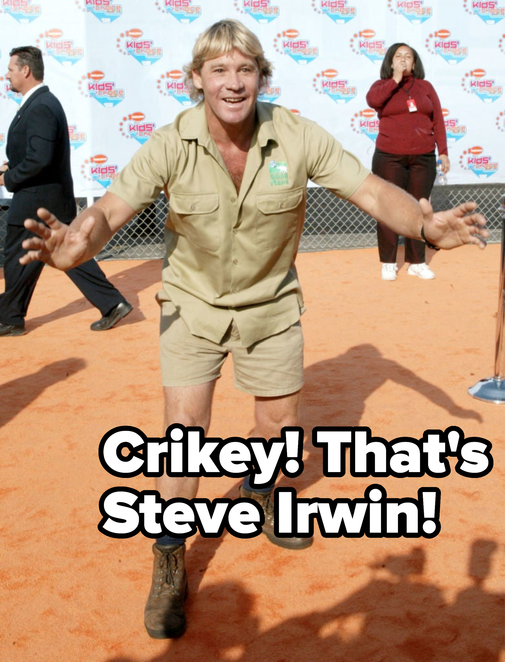 Steve Irwin in khaki shorts and shirt with his arms wide open at an event