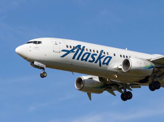Alaska Airlines aircraft in flight against clear sky