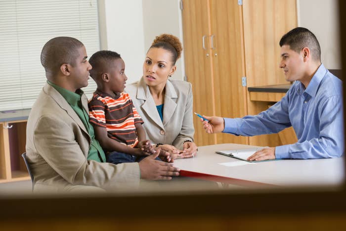 Family with child meeting a financial advisor in an office