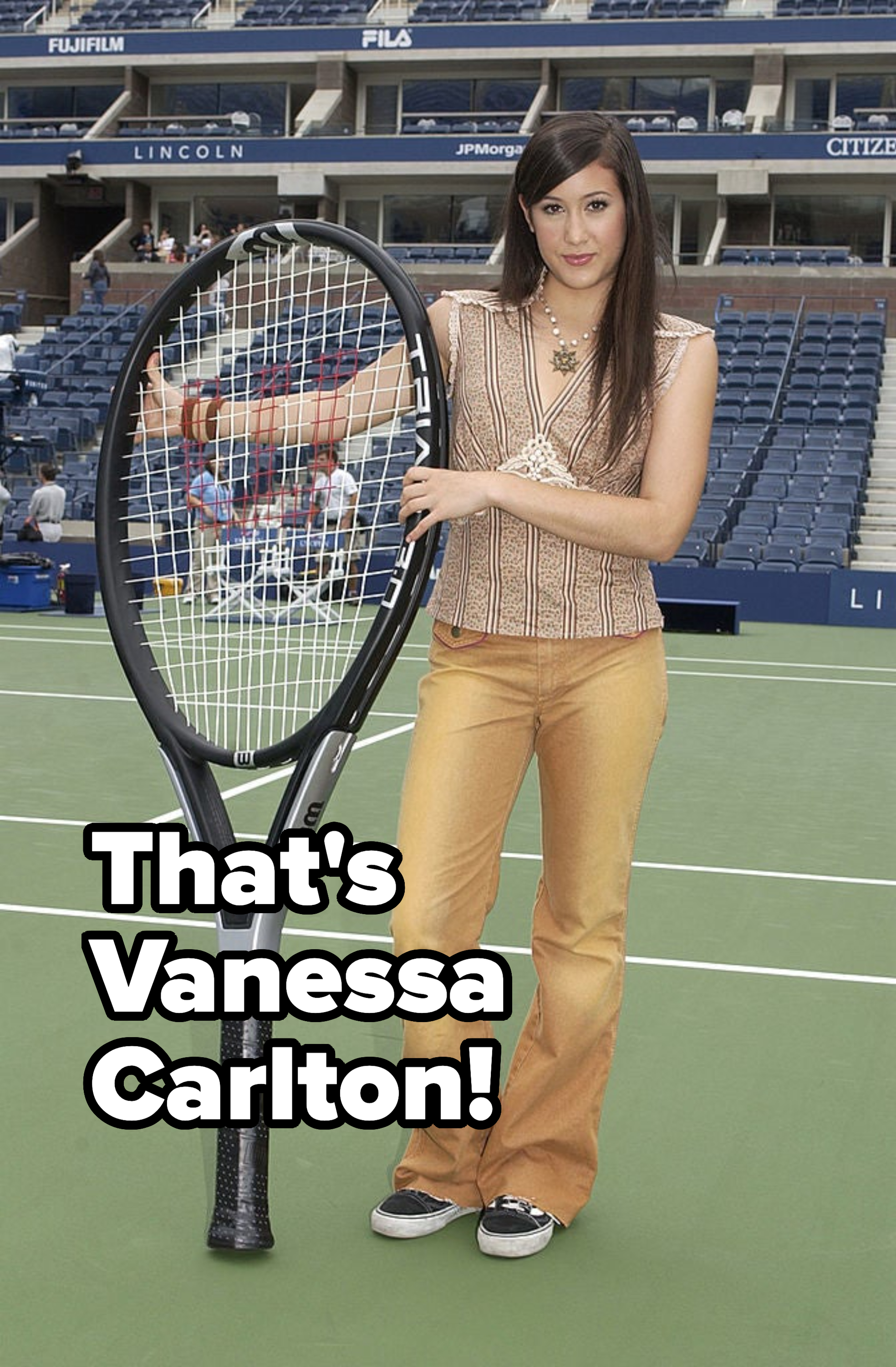Woman in striped top and flared pants holding oversized tennis racket on court