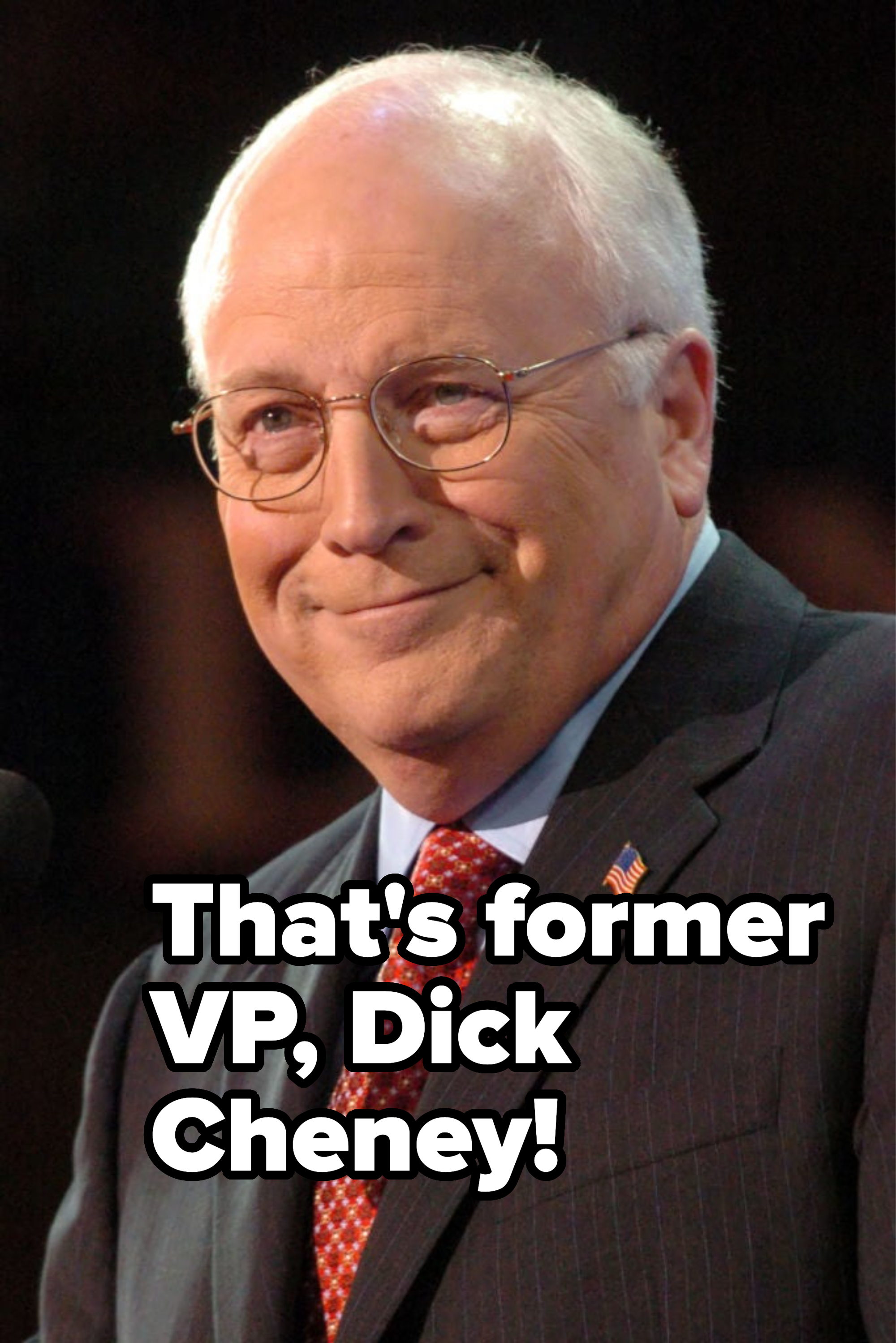 Man in suit with glasses and tie smiling at an event