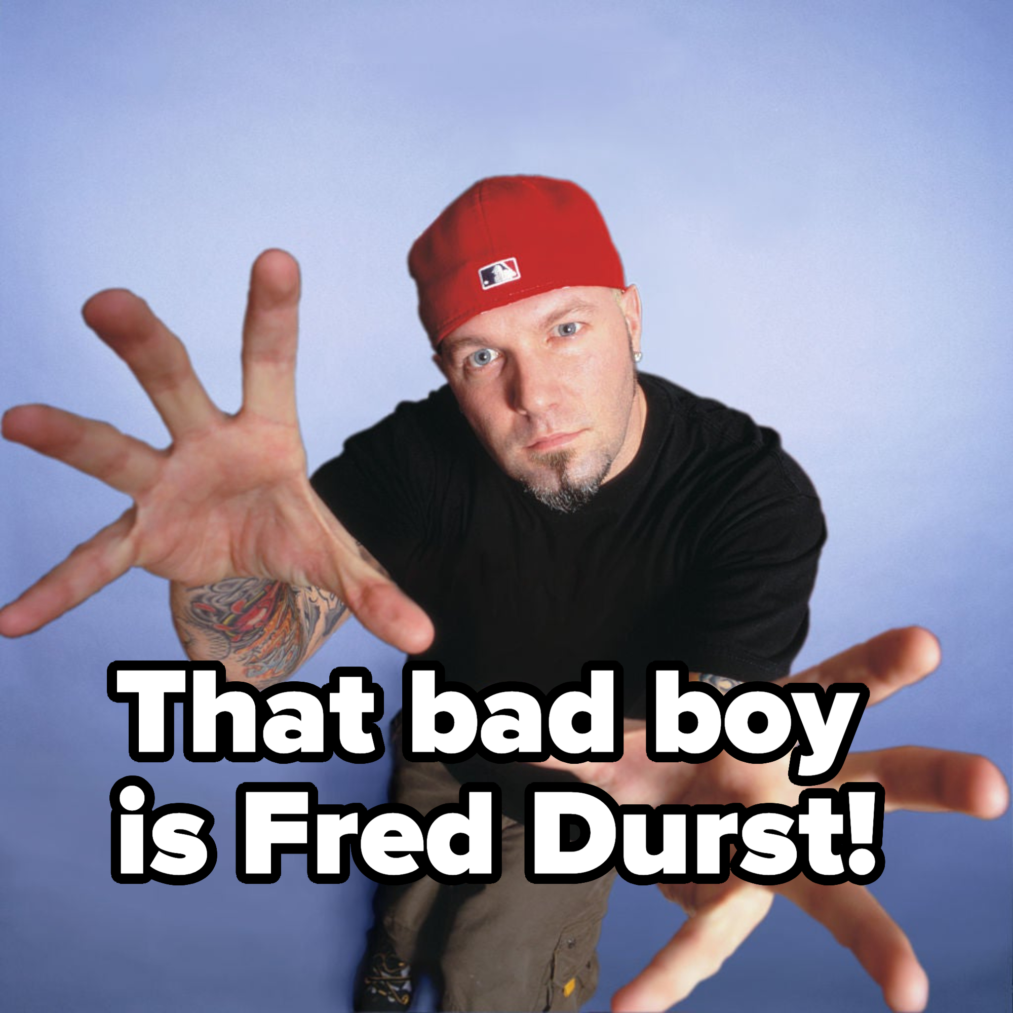 Celebrity in a black long-sleeve shirt and red hat reaching out to the camera