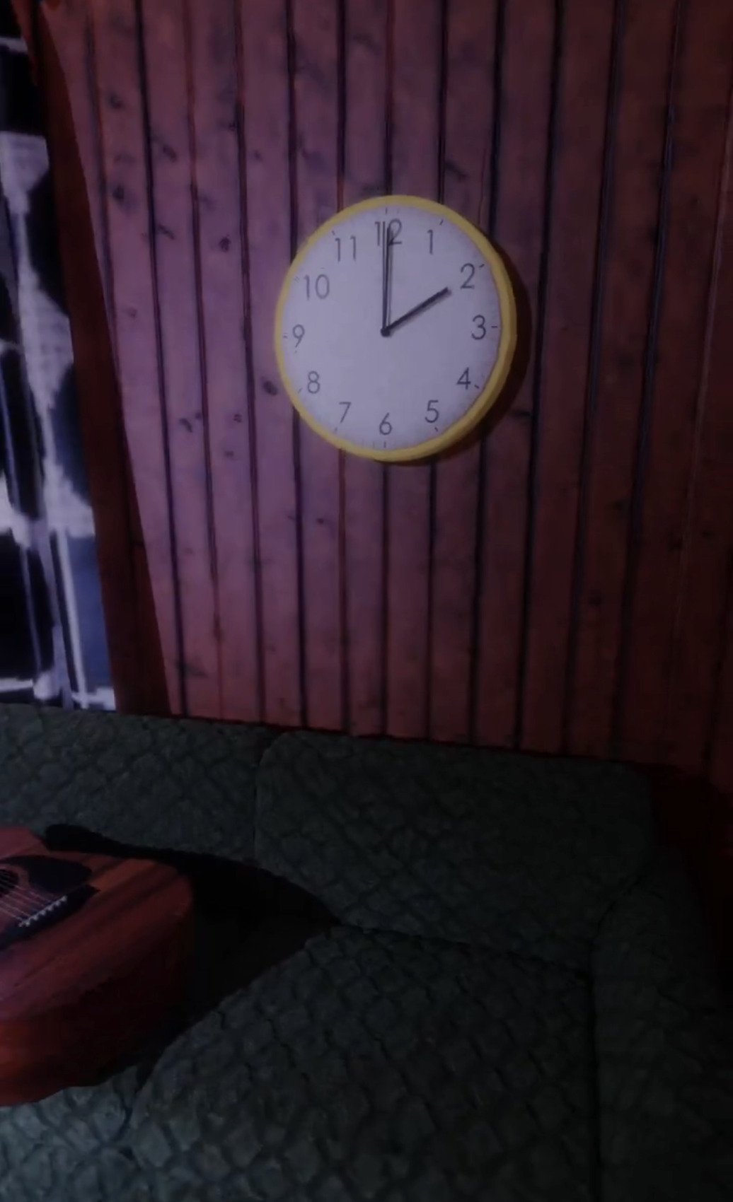 Analog clock showing time as 2 on wall above a quilted couch