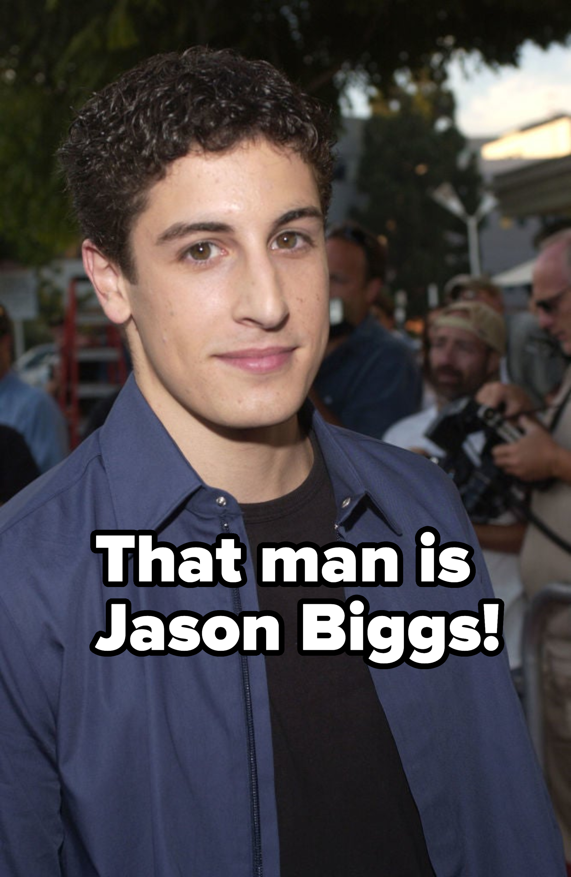 Young male celebrity in a blue shirt posing for the camera at an event