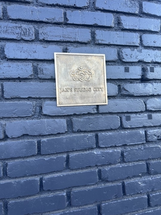 Plaque with &quot;SAS STUDIO CITY&quot; embossed, mounted on a brick wall