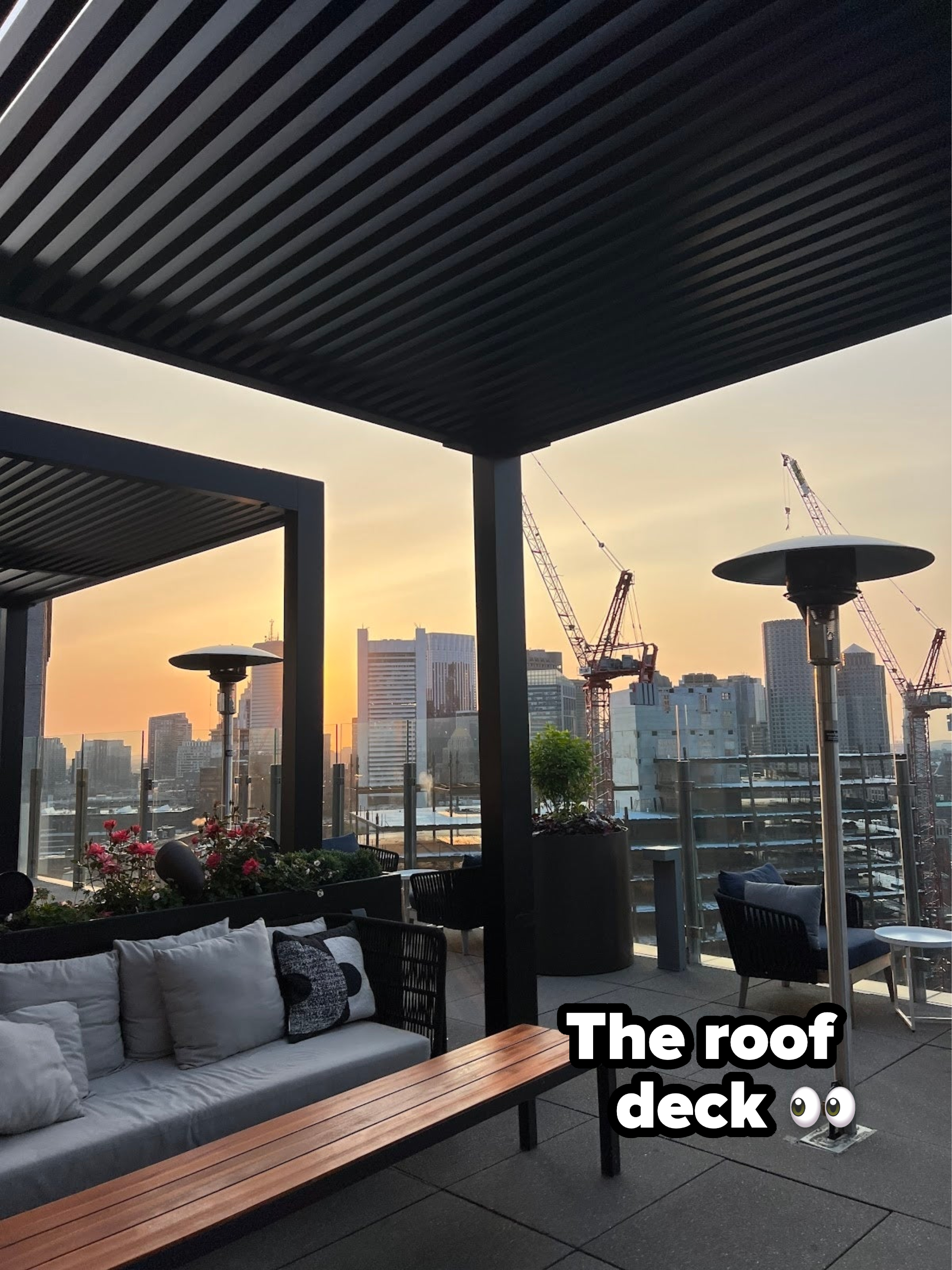 The roof deck featuring an outdoor patio with furniture during sunset