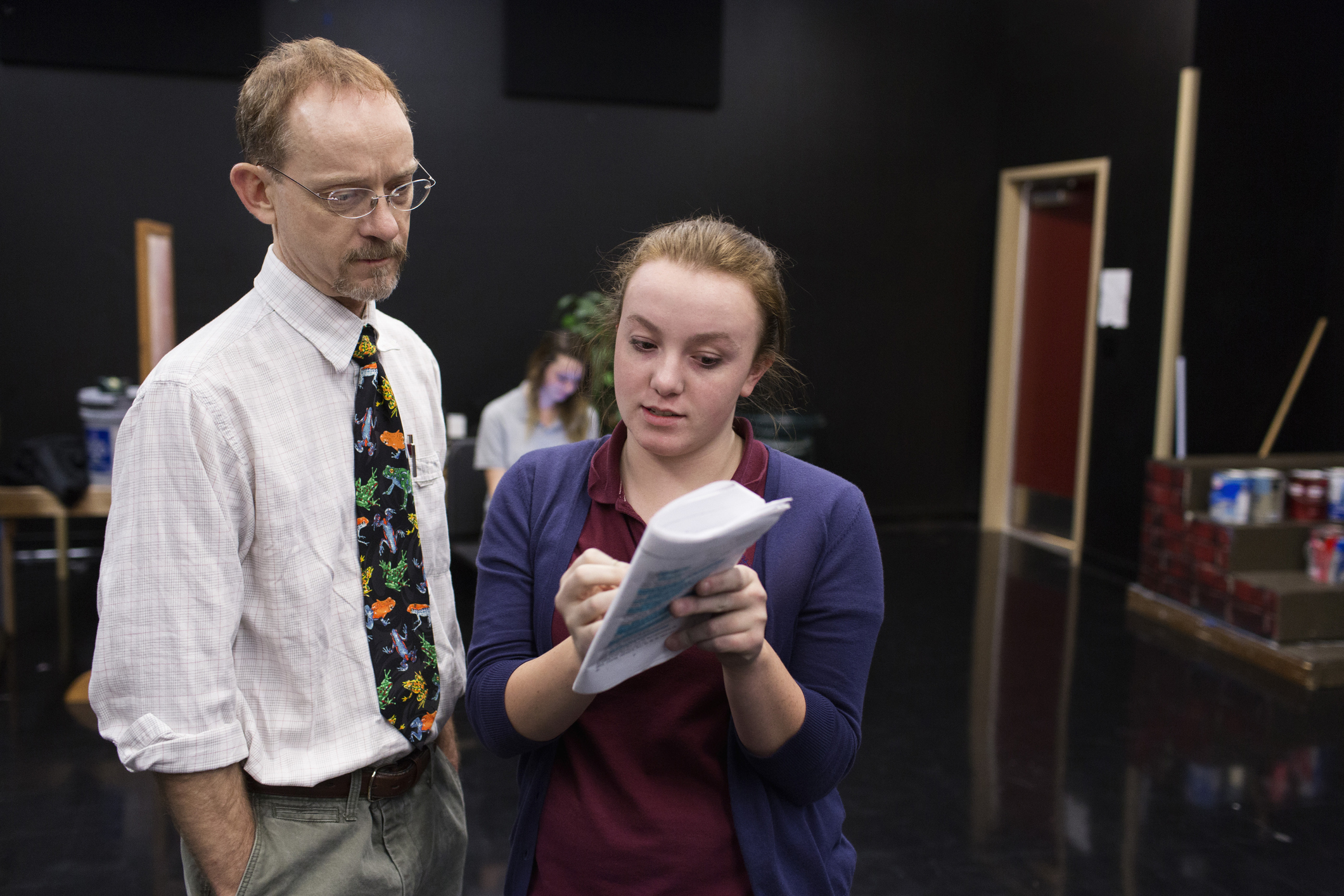 Two actors rehearsing a scene with a script in hand
