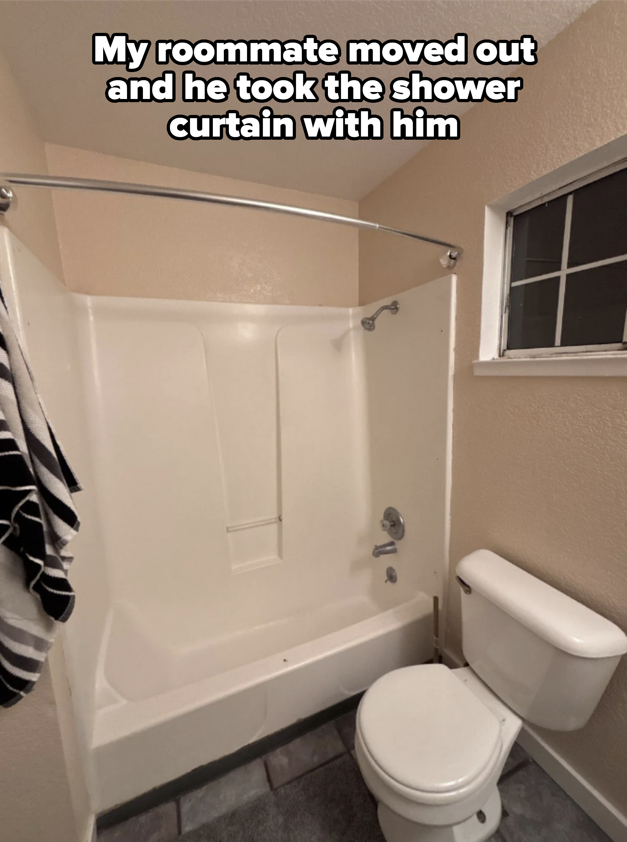 Bathroom interior with a shower-tub combo, toilet, and small window — and no shower curtain