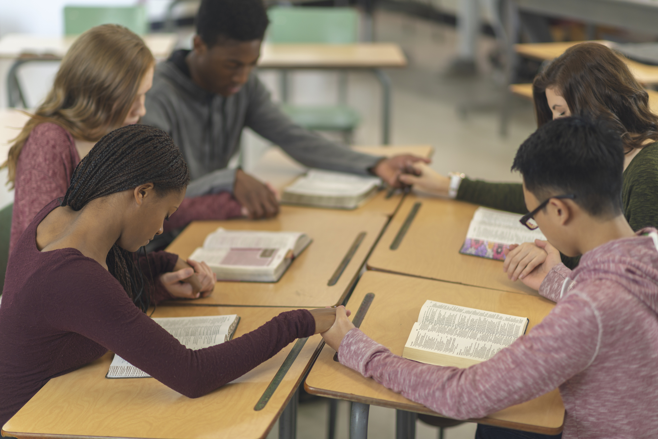 Students sitting around a table engaged in a study session with books and papers