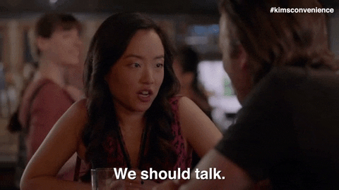 Two people at a table, one gesturing to initiate a conversation, subtitle reads &quot;We should talk.&quot;