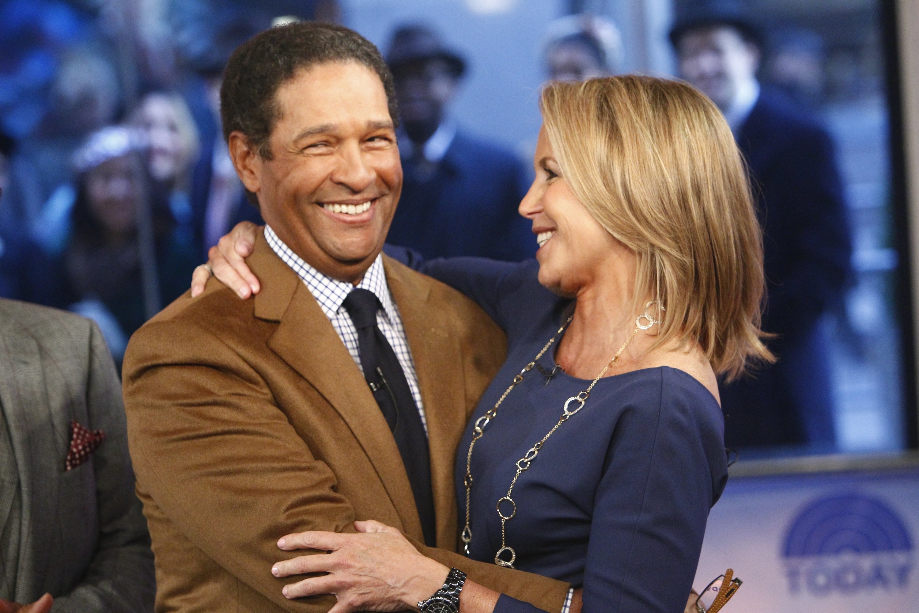 Bryant Gumbel and Katie Couric embracing and smiling