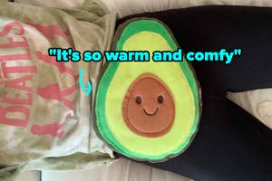 reviewer with avocado heating pad on stomach