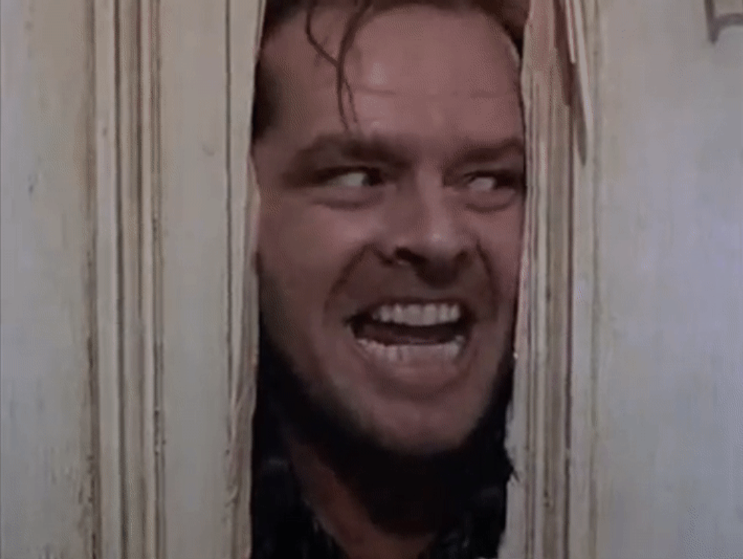Jack Nicholson&#x27;s character peeks through a broken door in a scene from &quot;The Shining.&quot;
