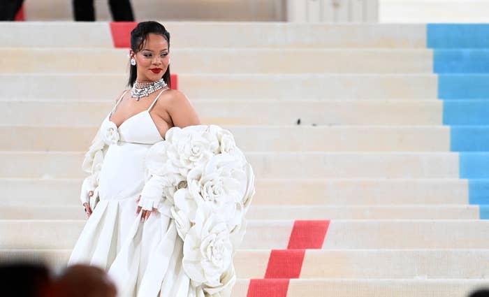 Rihanna posa en un vestido blanco con flores grandes y joyería llamativa en la Met Gala