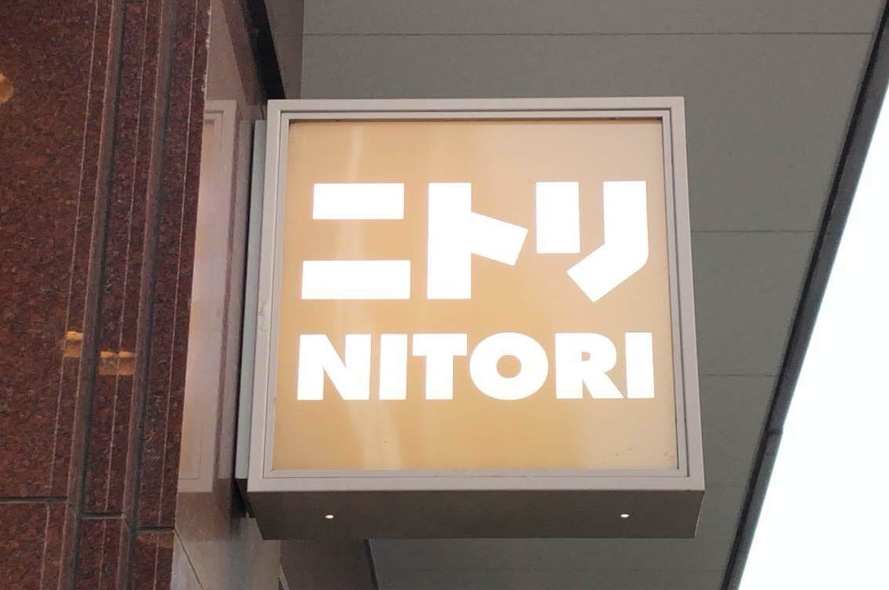 ニトリの店舗看板、オフィスビルの入り口上に掲示。