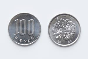 表と裏の日本の100円硬貨が並んでいる。