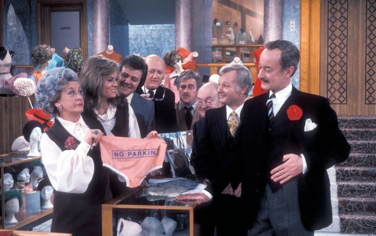 Cast of &quot;Are You Being Served?&quot; in a scene with Mrs. Slocombe holding up a pair of underwear with &quot;NO PARKING&quot; sign
