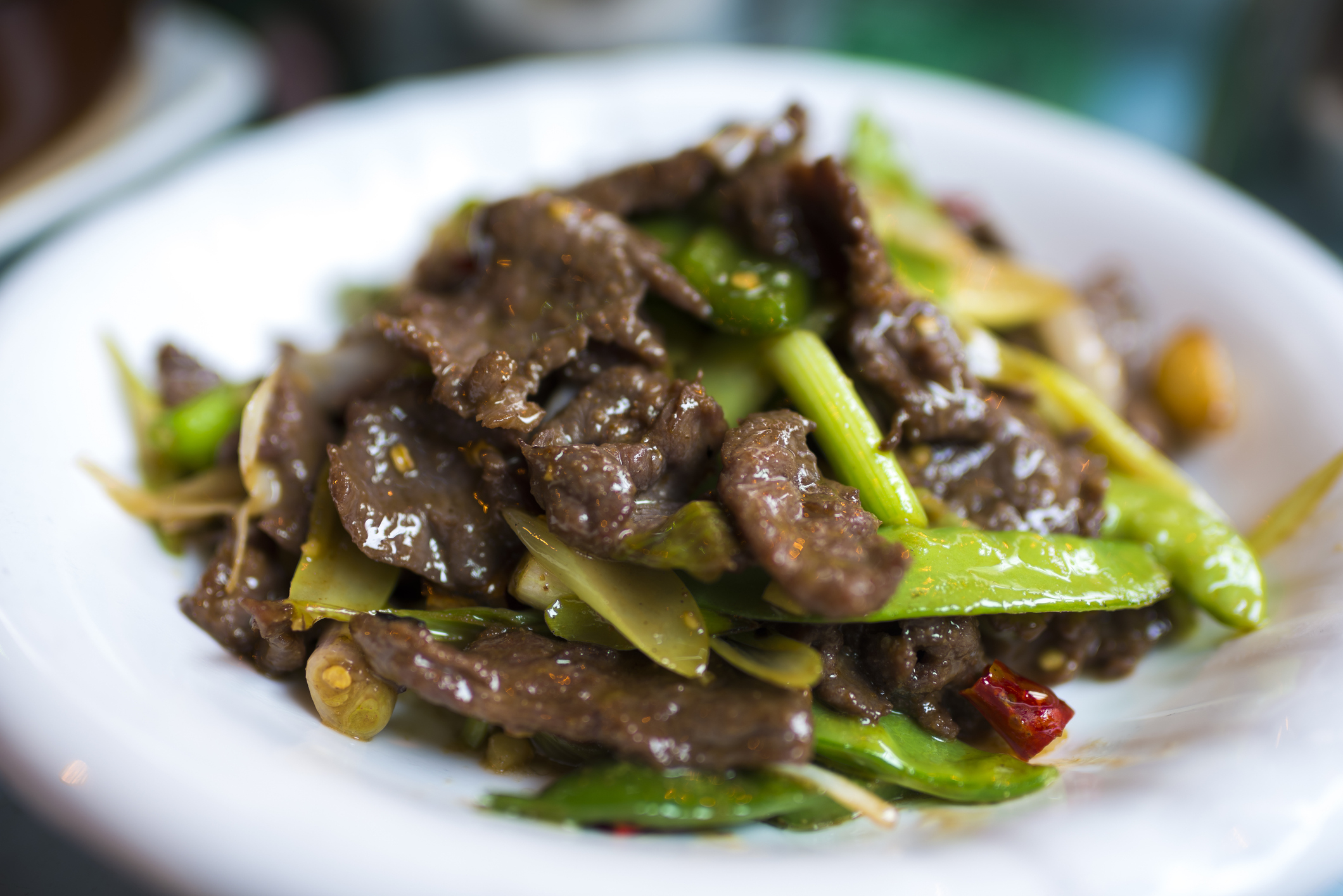 Plate of stir-fried beef with snap peas and vegetables