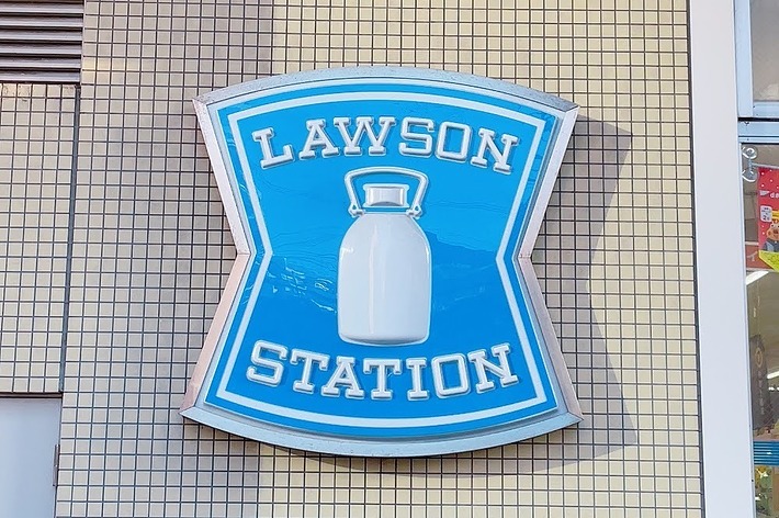 ローソンの店舗の外壁に取り付けられた、牛乳瓶の形をした青い看板。
