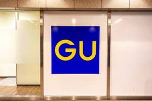 Signboard with the letters "GU" on a contrasting background, displayed at a store entrance