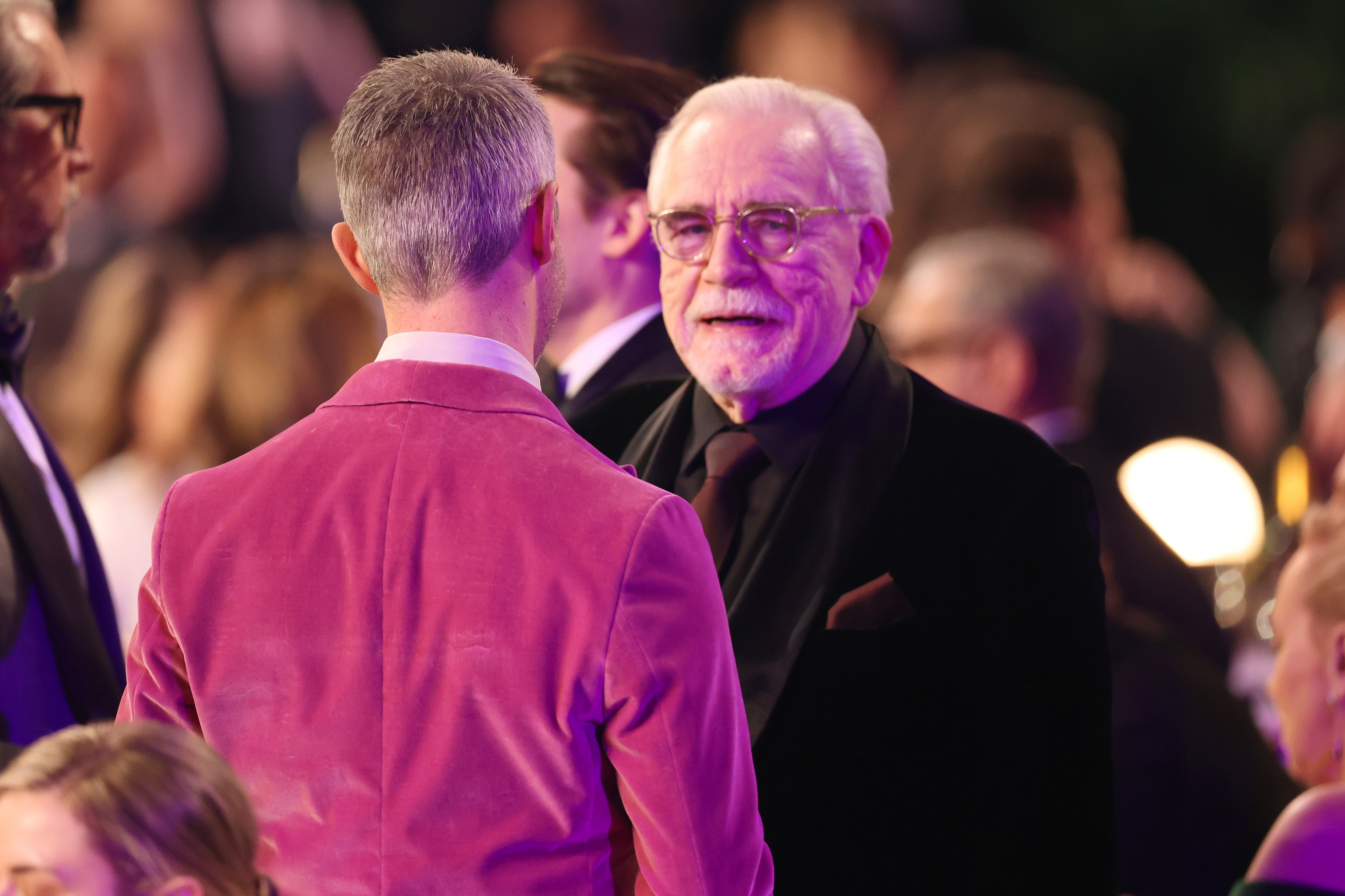 Closeup of Jeremy Strong and Brian Cox at an event