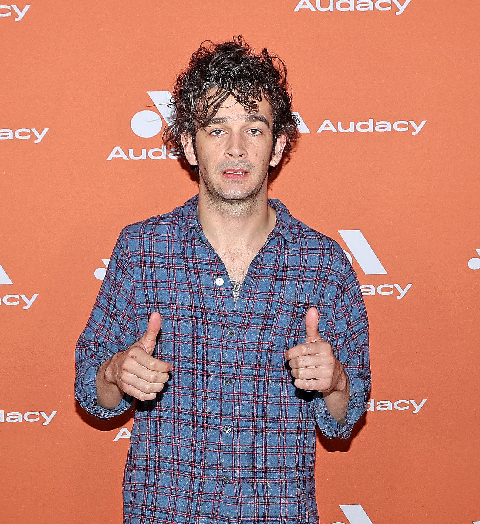 Matty Healy giving two thumbs up on the red carpet