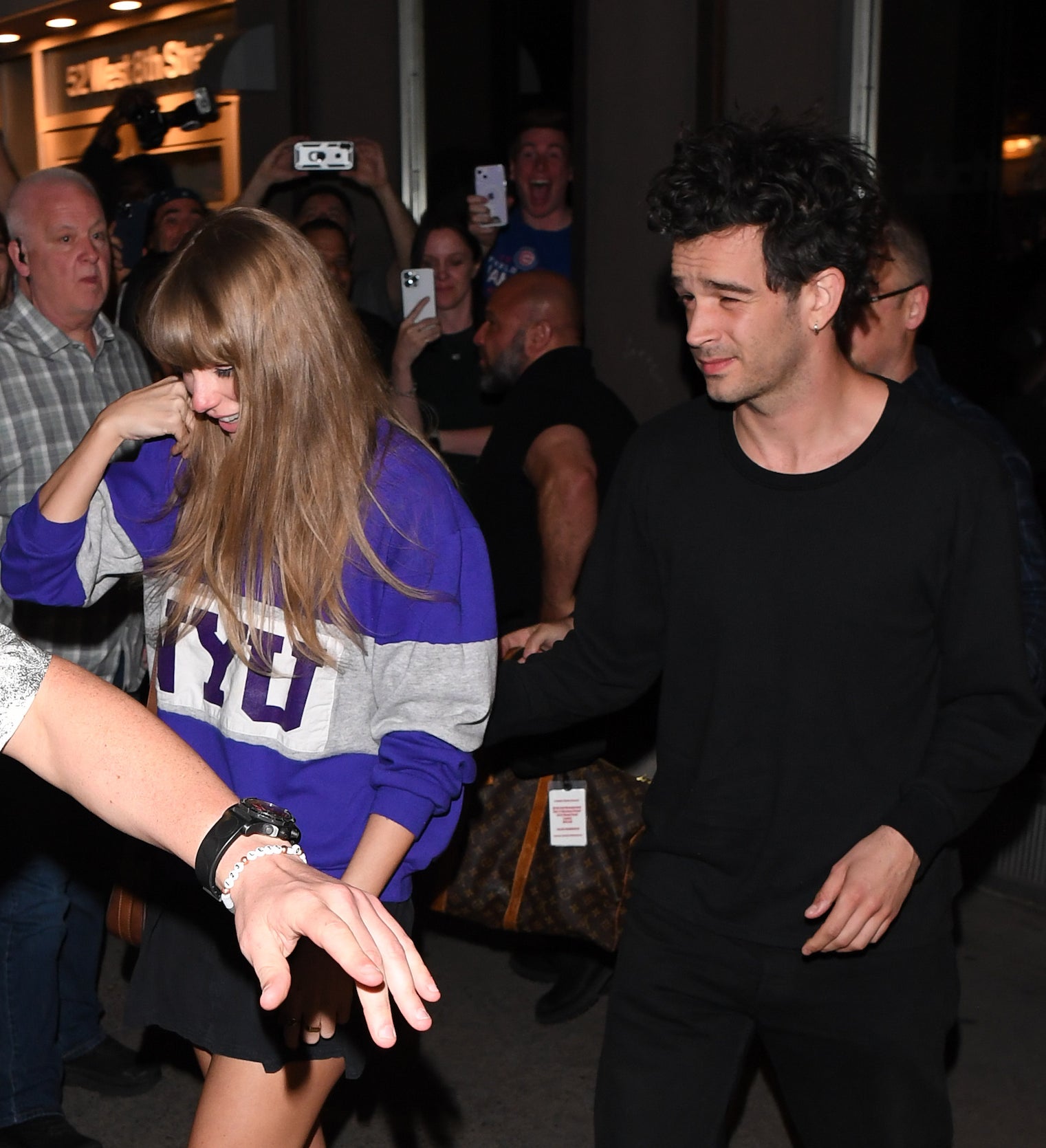 Taylor Swift in a casual top exits a building with Matty Healy