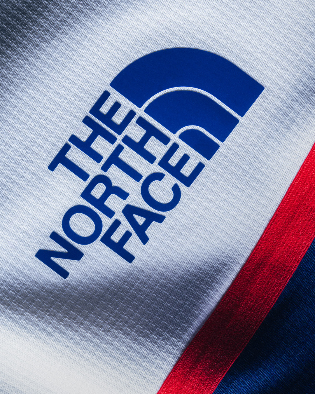Close-up of The North Face logo on textured fabric with red and blue color accents