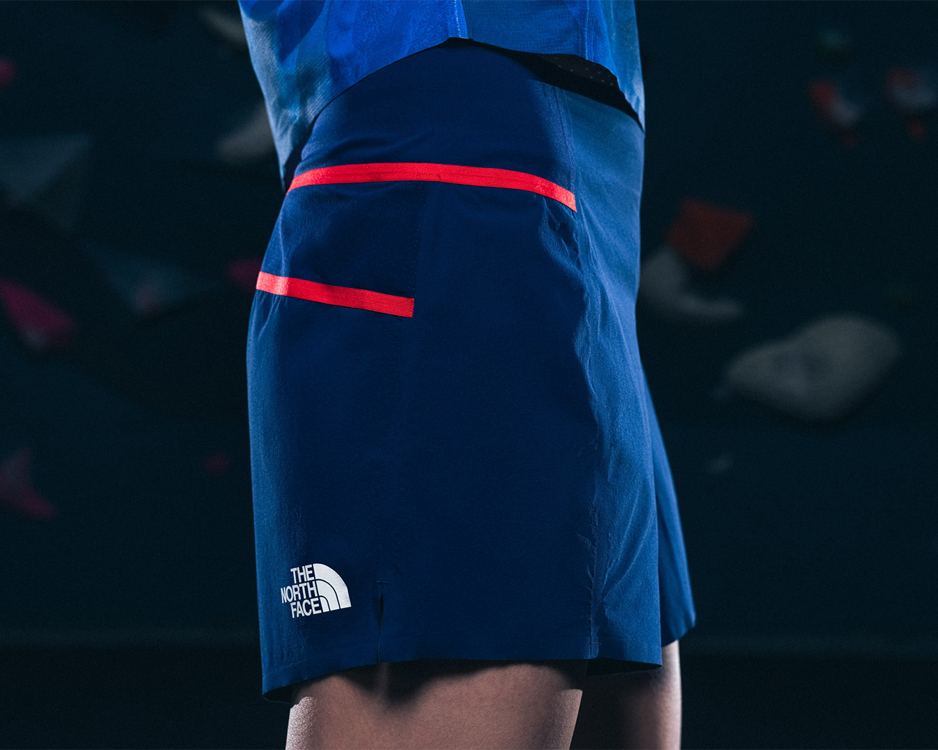 Close-up of a person in a blue and red The North Face skirt, focusing on the style and brand logo