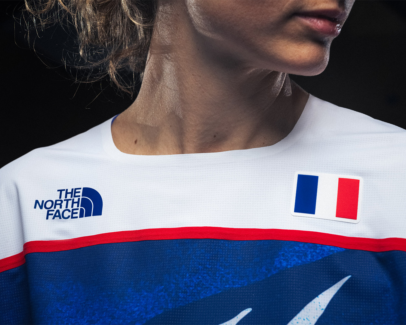 Close-up of a person wearing a North Face sports jersey with a French flag emblem