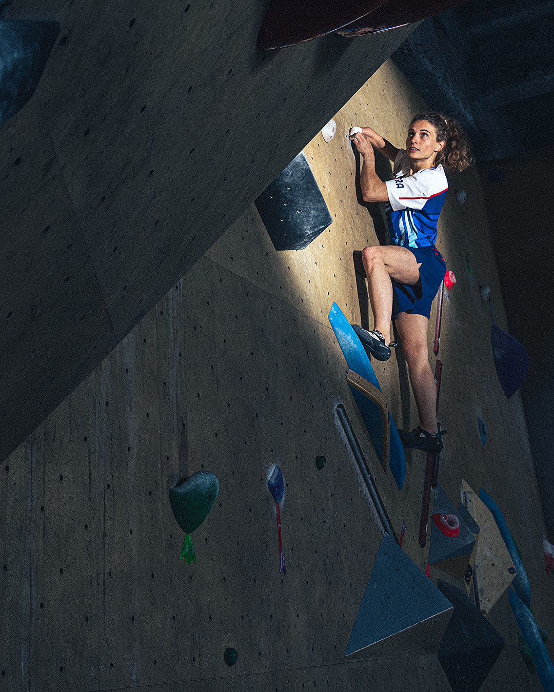 Athlete climbing an indoor rock wall in a competition setting