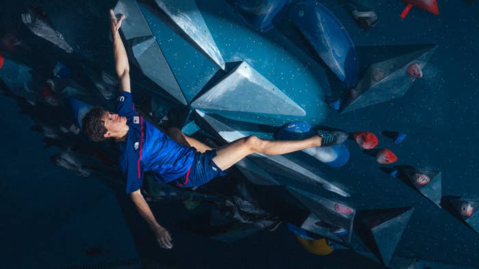 Person in athletic wear rock climbing on an indoor climbing wall